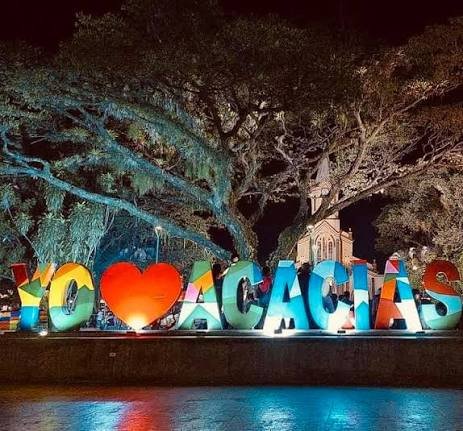 Letras de Acacías iluminadas de noche bajo un árbol de samán